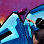 "Einfach mal Farbe drauf" Mann mit Farbroller auf Wand