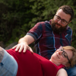 "Papa kümmert sich" Mann berührt Bauch von Frau, Vater und Mutter